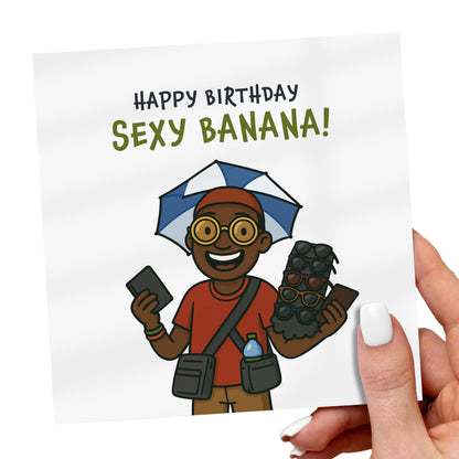 Birthday card with cartoon character holding a camera and umbrella, text 'Happy Birthday Sexy Banana!'