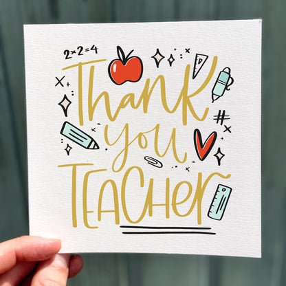 Card with 'Thank you teacher' text and educational icons held by a hand against a blurred background