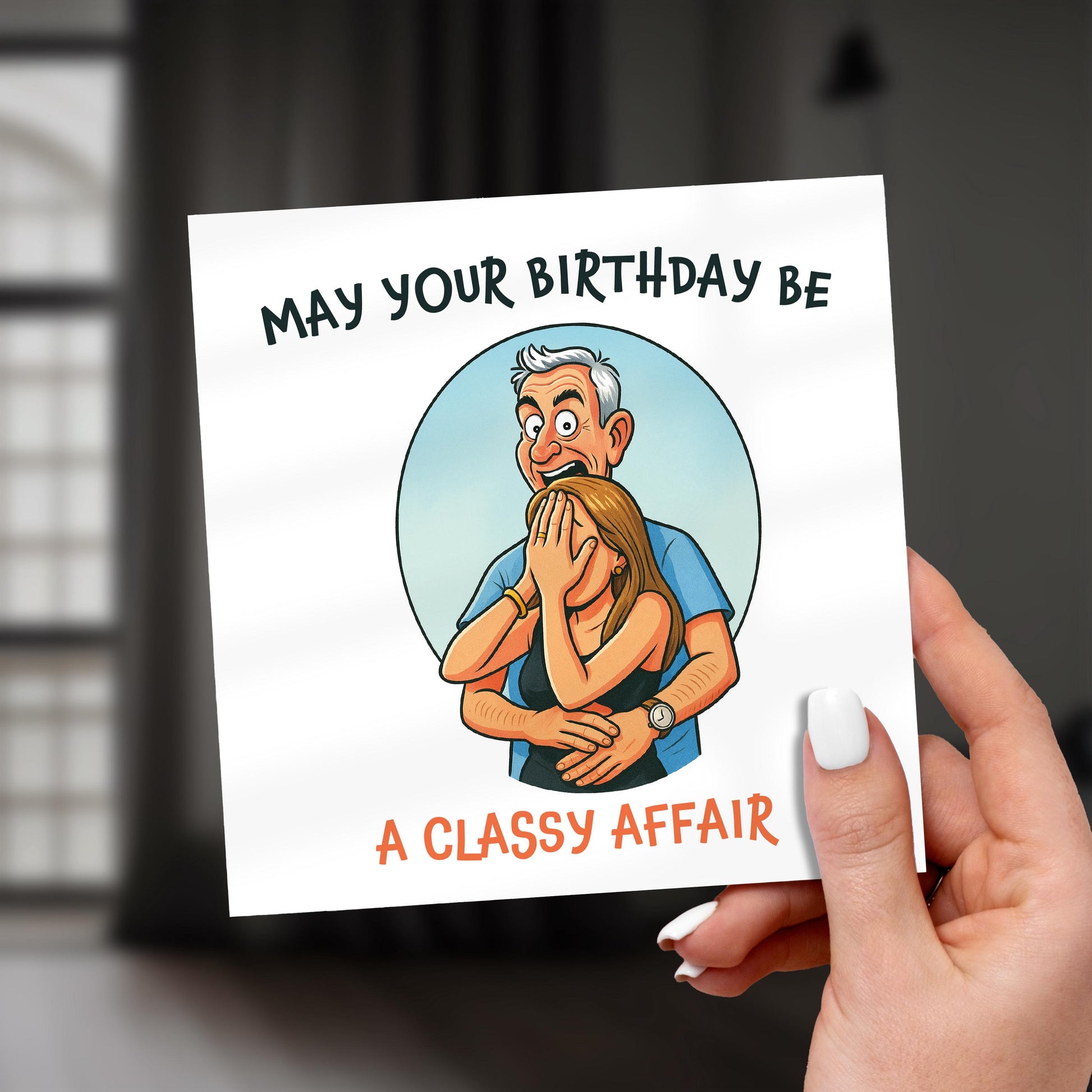 Hand holding a birthday card with cartoon illustration and text.