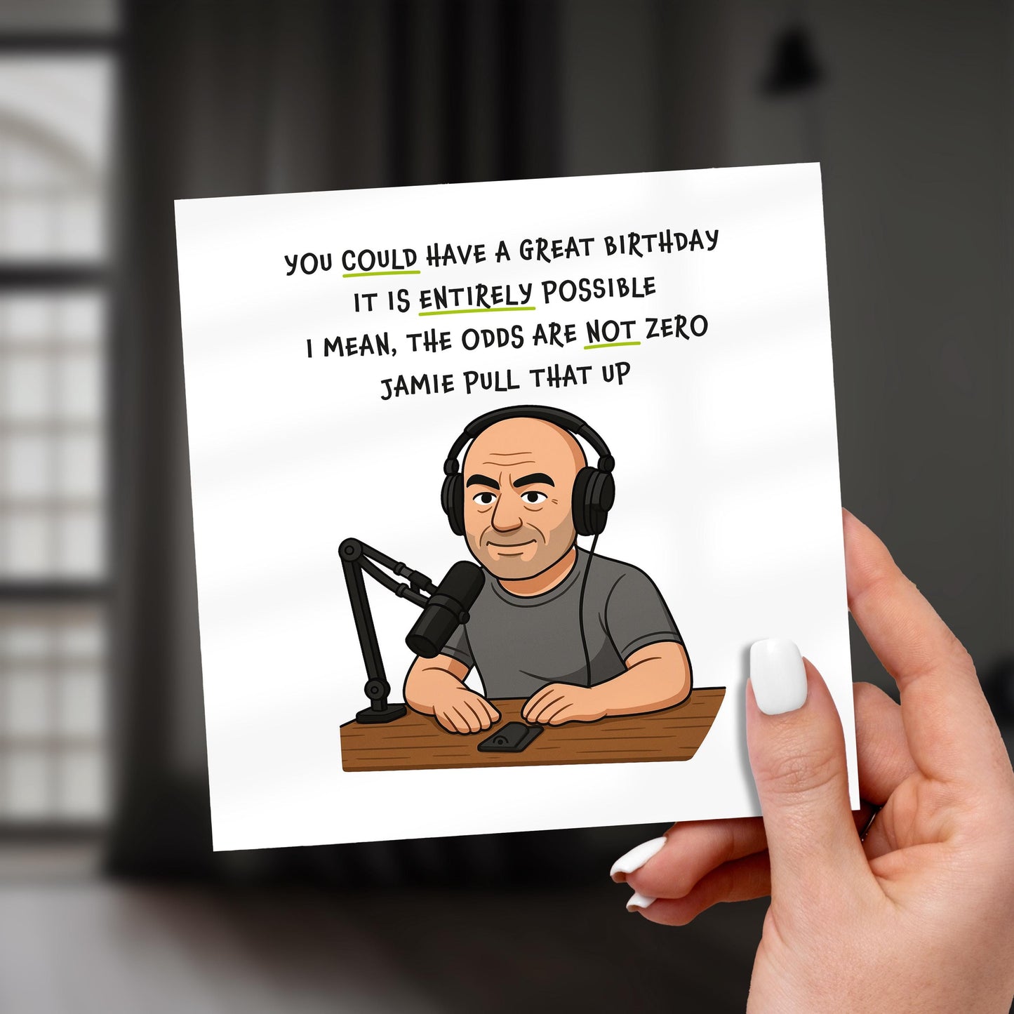 Card with a cartoon of a man in a radio studio and humorous text, held by a hand.