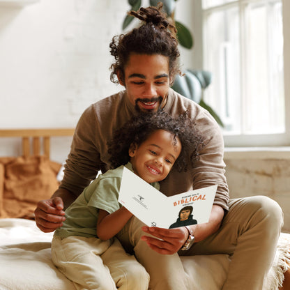 Man and child sitting together, reading a book indoors.