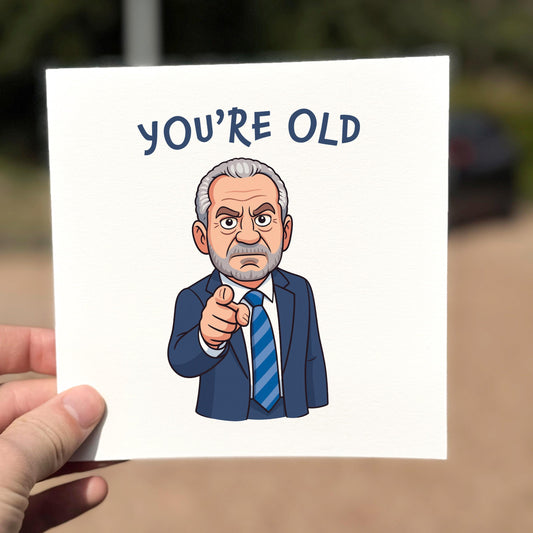 Square illustrated card featuring a stern cartoon man in a navy suit and striped tie, pointing directly at the viewer. Text above reads “YOU’RE OLD” in bold blue font. The background is plain white, with a blunt, savage, and humorous tone.