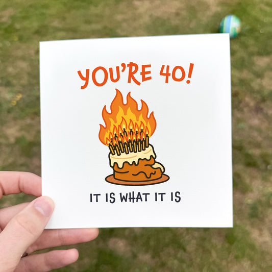 Funny 40th birthday card with an illustration of a cake overloaded with candles, set on fire, and the phrase “It is what it is” referencing Love Island.