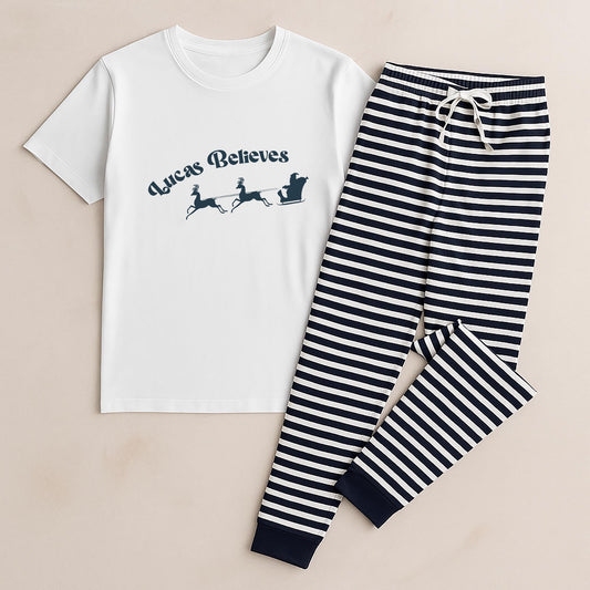 Children's pajama set with white t-shirt and striped pants on a beige background