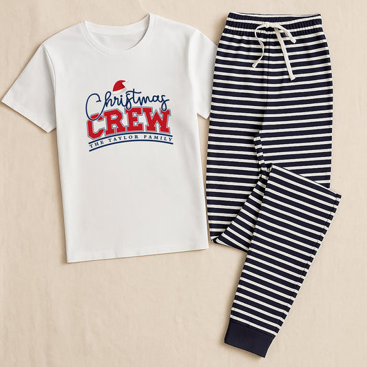 White t-shirt with 'Christmas Crew' text and navy striped pants on a beige background